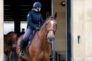 Cavalière de la garde républicaine à cheval en tenue officielle devant un bâtiment